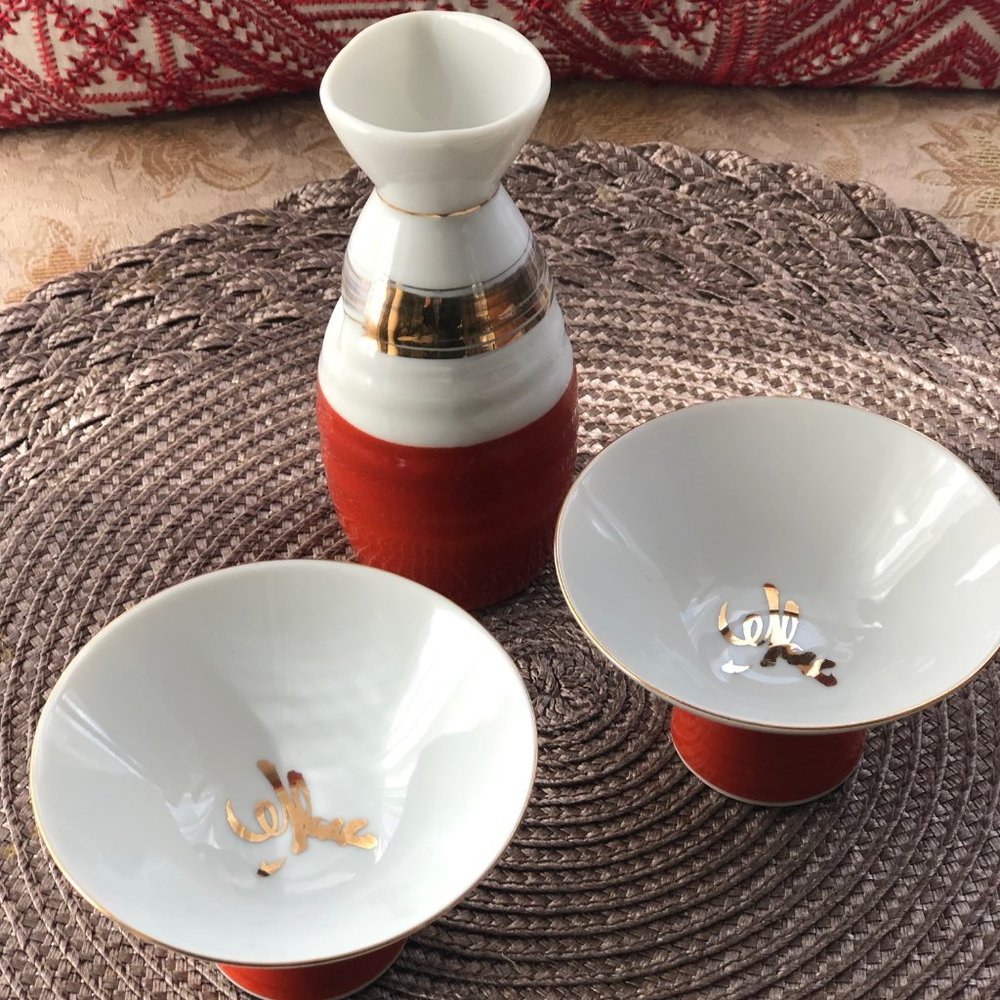 Japanese Deluxe Porcelain Red, Gold and White Sake Bottle and Cup Set.